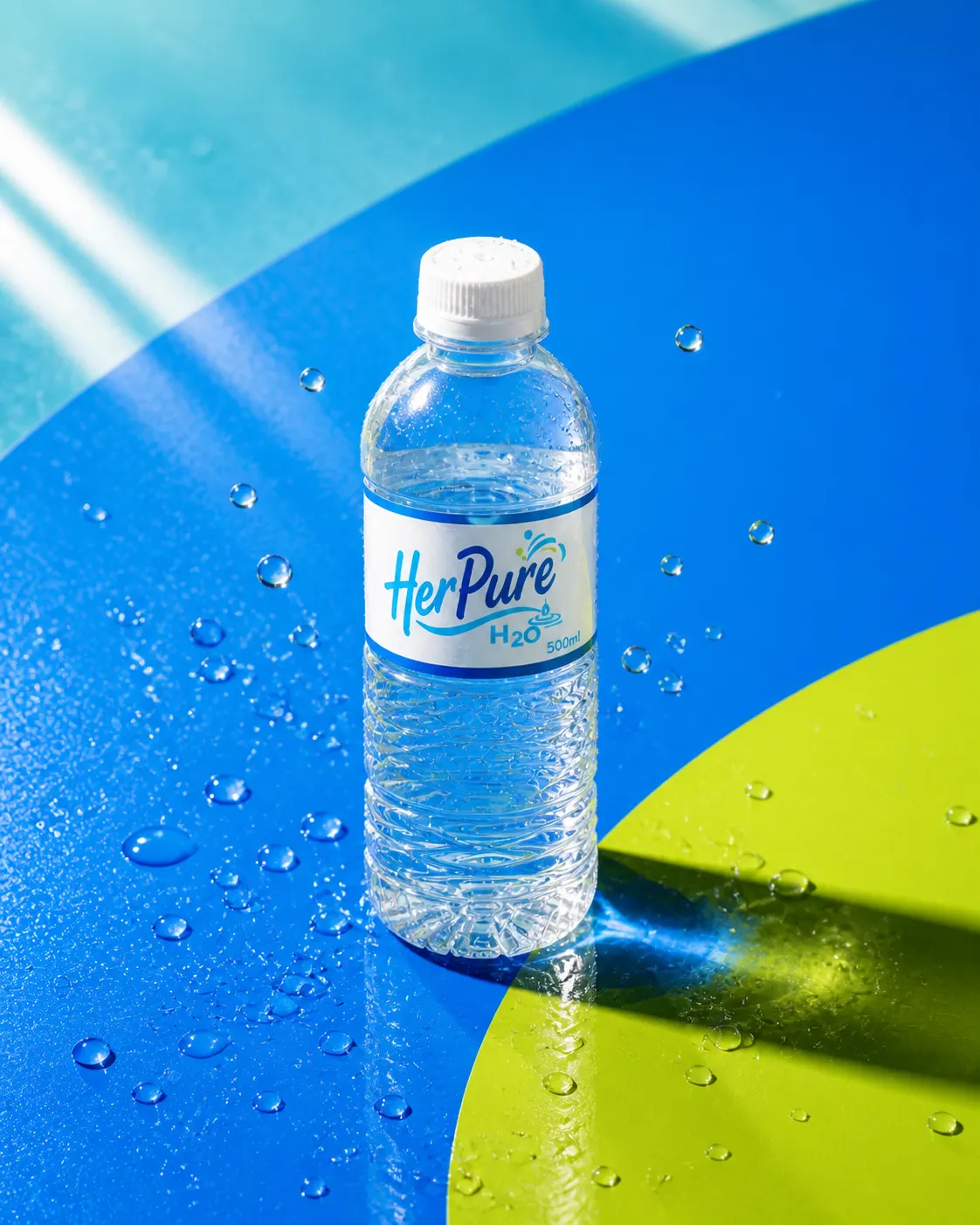 A compact Her Pure 500ml PET bottle with water droplets on a bold blue and lime surface
